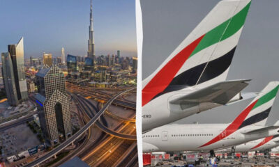 Dubai skyline at dusk with complex highway interchanges on the left; Emirates aircraft tails on the right.