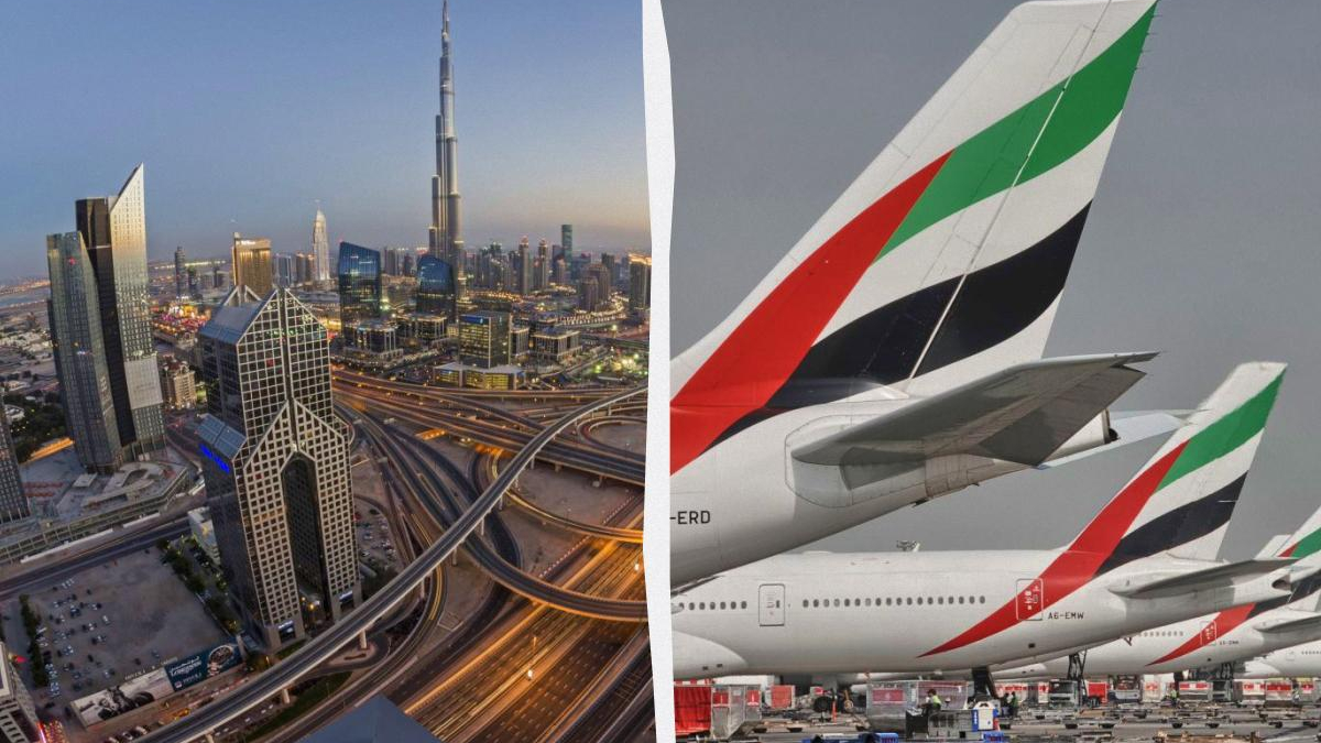 Dubai skyline at dusk with complex highway interchanges on the left; Emirates aircraft tails on the right.