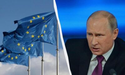 Left: waving European Union flags against a blue sky; right: a stern man in a dark suit and purple tie speaking, with a blue backdrop; divided by a curved white line.