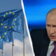 Left: waving European Union flags against a blue sky; right: a stern man in a dark suit and purple tie speaking, with a blue backdrop; divided by a curved white line.