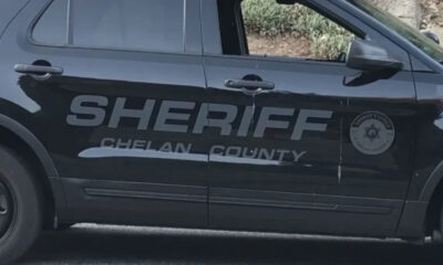 Side view of a Chelan County Sheriff SUV with large 'SHERIFF' lettering and a circular sheriff badge on the door