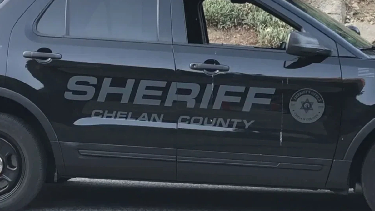 Side view of a Chelan County Sheriff SUV with large 'SHERIFF' lettering and a circular sheriff badge on the door