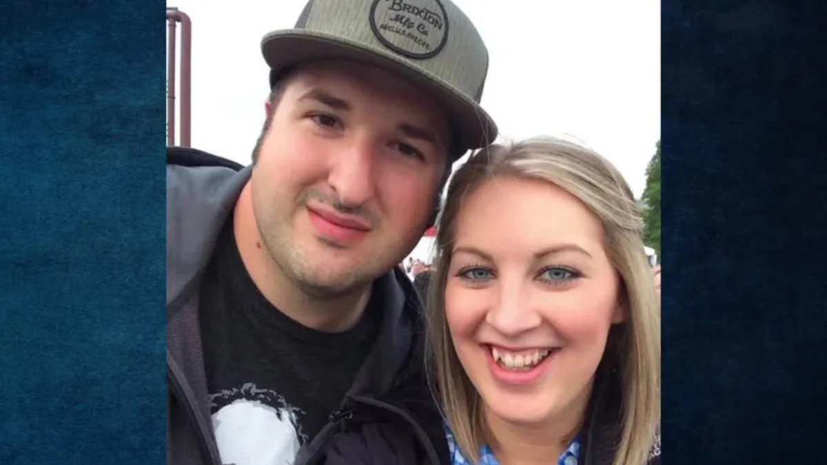Smiling man and woman taking a selfie outdoors, facing the camera with heads close together.
