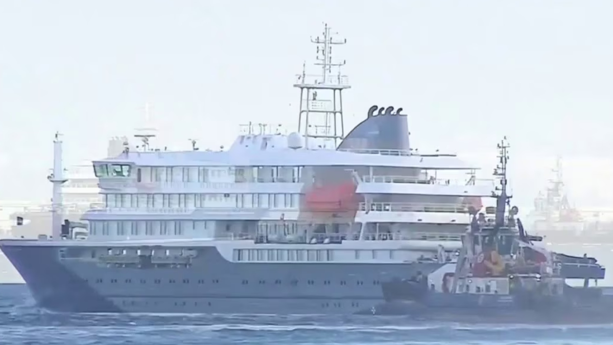 Large luxury yacht being assisted by a tugboat on calm sea