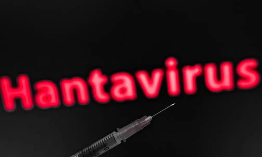 Syringe in the foreground with blurred red 'Hantavirus' text in the dark background, suggesting a health risk or vaccine topic.