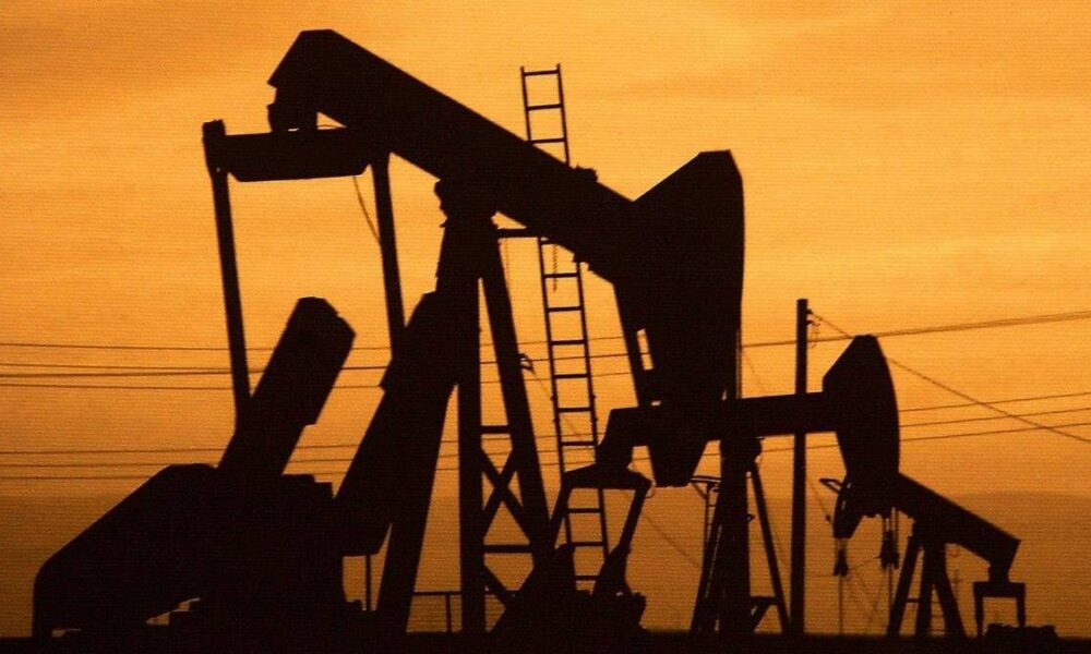 Silhouetted oil pumpjacks against an orange sunset sky.