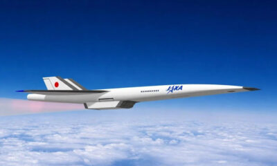 Concept supersonic jet with JAXA branding flying above clouds in clear blue sky, Japan flag on tailfin.