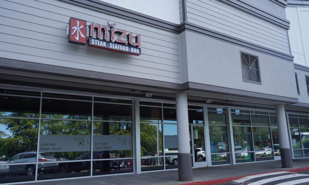 Exterior of Mizui restaurant storefront with sign reading Mizui and 'Steak · Seafood · Bar' above large glass windows