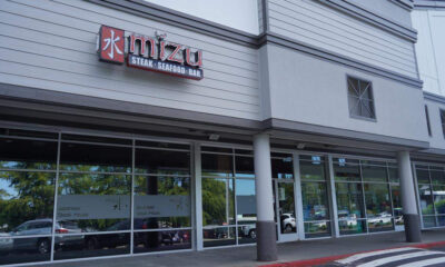 Exterior of Mizui restaurant storefront with sign reading Mizui and 'Steak · Seafood · Bar' above large glass windows