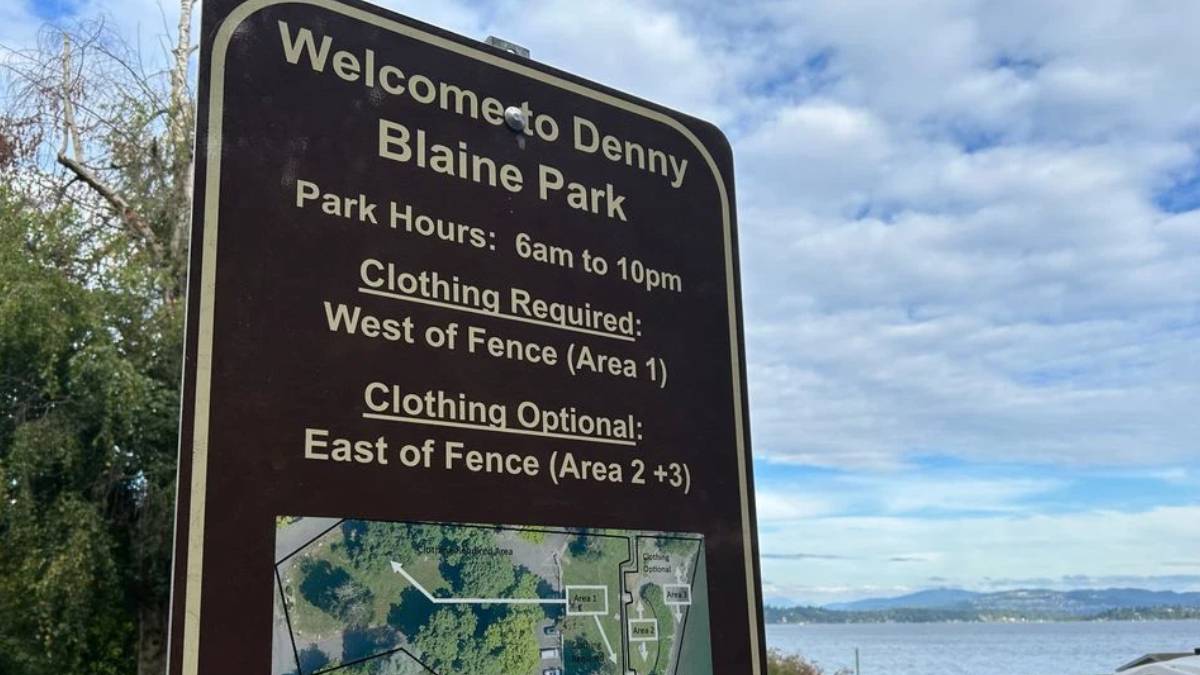 Park sign that reads: Welcome to Denny Blaine Park; hours 6am–10pm; clothing required west of fence (Area 1); clothing optional east of fence (Areas 2+3).
