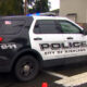 Black-and-white City of Kirkland police SUV with blue emergency lights, parked on a street; side reads POLICE, CITY OF KIRKLAND, and a motto below.