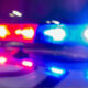Blurred red and blue emergency lights from a police car at night (sirens active)