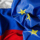 Russian flag partially draped over the European Union flag with yellow stars on blue field and red stripe visible at the bottom left