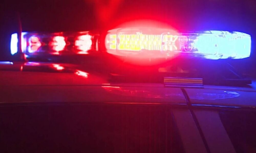Police car roof lights flashing red and blue at night, indicating an emergency