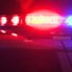 Police car roof lights flashing red and blue at night, indicating an emergency