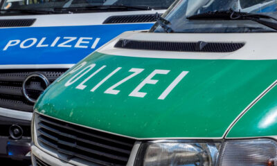 Close-up of two German police vans, green and blue fronts with 'POLIZEI' lettering.