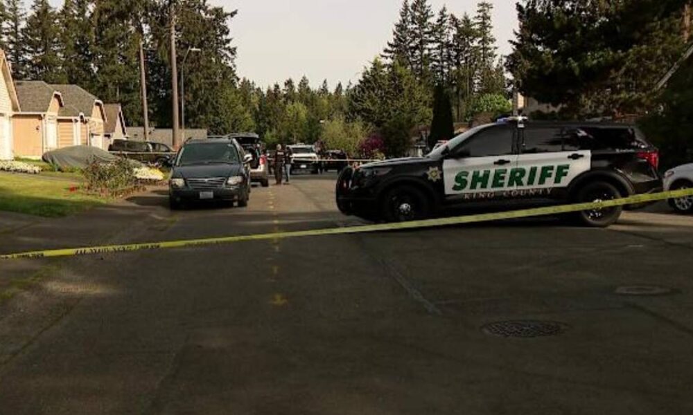 Sheriff patrol SUV blocks a residential street with yellow tape as investigators work in the background.