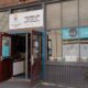 Open storefront of a learning center with a 'Now Enrolling' banner and blue window decals reading 'The City in a Classroom.'