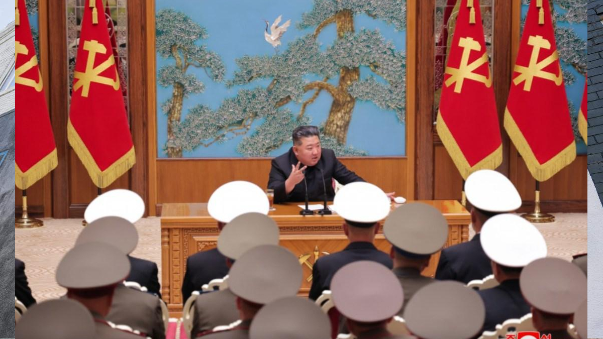 Kim Jong Un speaks at a wooden podium in a formal hall with red flags beside him and a blue mural behind