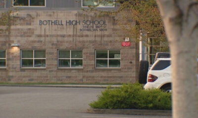 Exterior of Bothell High School building with a stone facade and a white SUV in the parking lot.