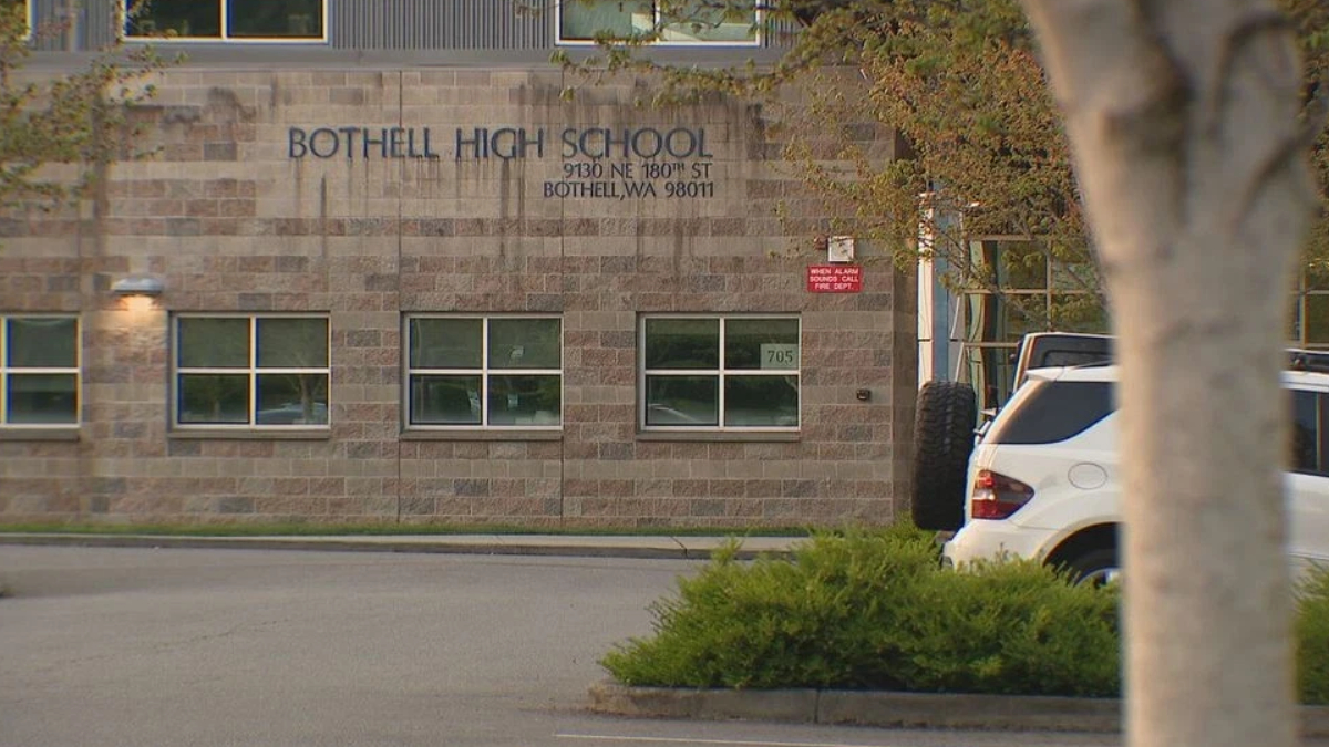 Exterior of Bothell High School building with a stone facade and a white SUV in the parking lot.