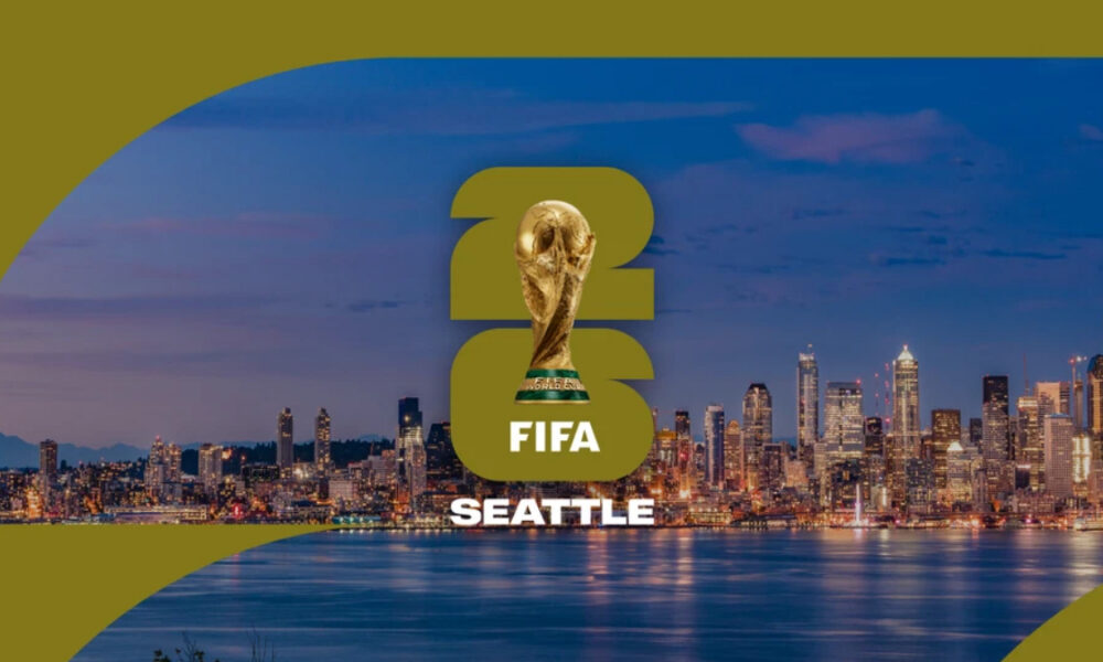 Seattle FIFA World Cup banner showing the trophy above the 'FIFA SEATTLE' text over a city skyline at dusk.