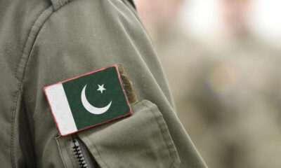 Close-up of a military uniform sleeve with a Pakistan flag patch sewn on the pocket area.