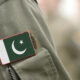 Close-up of a military uniform sleeve with a Pakistan flag patch sewn on the pocket area.