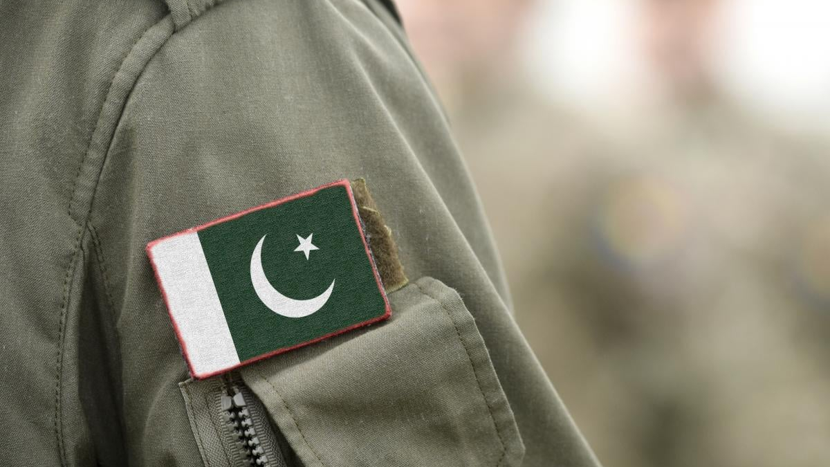 Close-up of a military uniform sleeve with a Pakistan flag patch sewn on the pocket area.