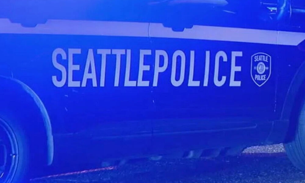 Side view of a Seattle Police Department patrol car with bold 'SEATTLEPOLICE' lettering and the department shield.