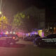 Night scene of Seattle Police Department vehicles with flashing red and blue lights blocking a street at night.