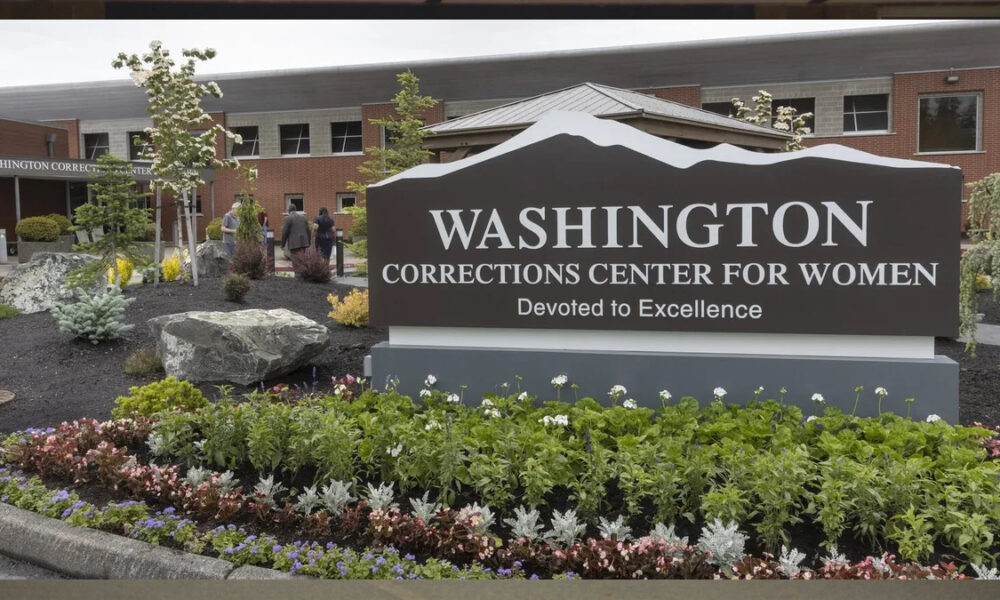Exterior sign for Washington Corrections Center for Women with a landscaped flower bed in front.