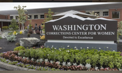Exterior sign for Washington Corrections Center for Women with a landscaped flower bed in front.