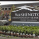 Exterior sign for Washington Corrections Center for Women with a landscaped flower bed in front.