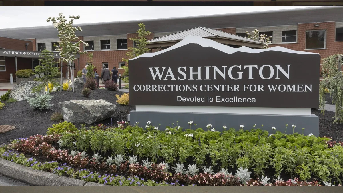 Exterior sign for Washington Corrections Center for Women with a landscaped flower bed in front.