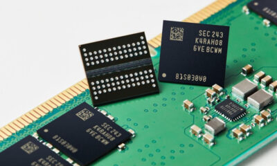 Close-up of memory chips on a green circuit board with a gold edge connector, showing electronic components and circuitry nearby.