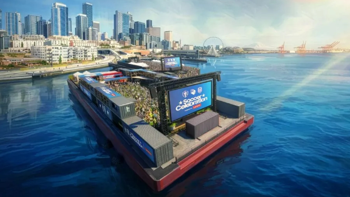 Floating water-stage with a large crowd watching a soccer celebration event by the city skyline and harbor.