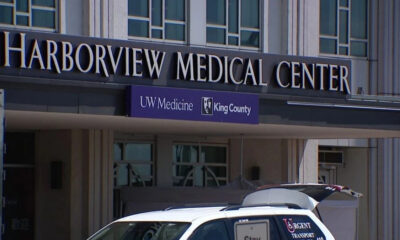 Facade of Harborview Medical Center with UW Medicine King County banner and a white transport van in front.