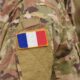 Soldier in camouflage uniform with a French flag patch on the sleeve.