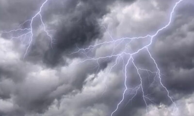 Dark storm clouds with bright jagged lightning bolts streaking across the sky.