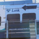 Front section of a blue-and-white passenger train with the word 'Link' and a large black arrow, partial '139B' number, and safety wording on the door area.