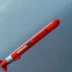 Red rocket streaking upward diagonally over a blue sea horizon.