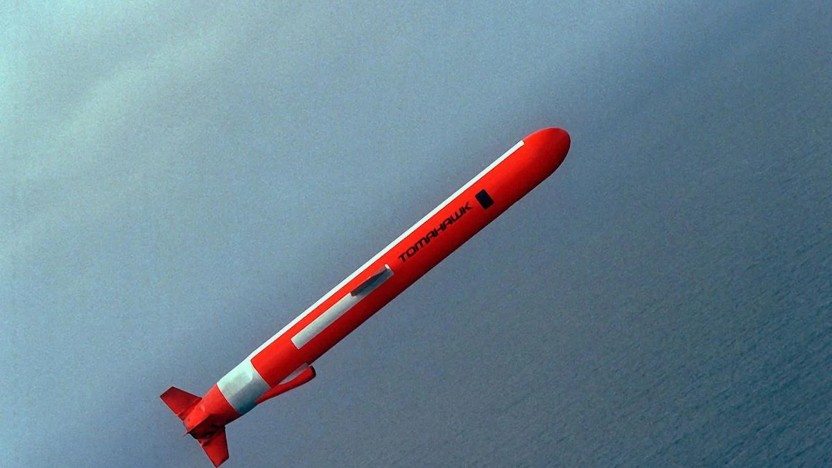 Red rocket streaking upward diagonally over a blue sea horizon.