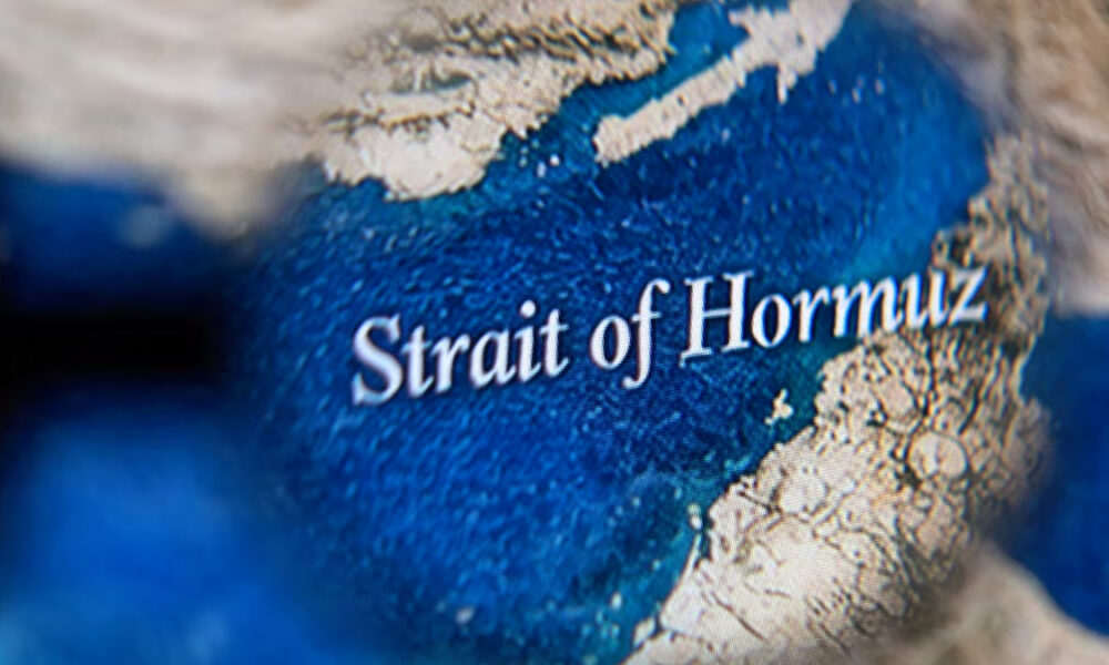 Close-up of a map highlighting the Strait of Hormuz, with blue ocean and surrounding beige land.