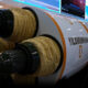Large rocket engine on display with white fuselage and orange stripes labeled YILDIRIMHAN; visitors and screens in the background.