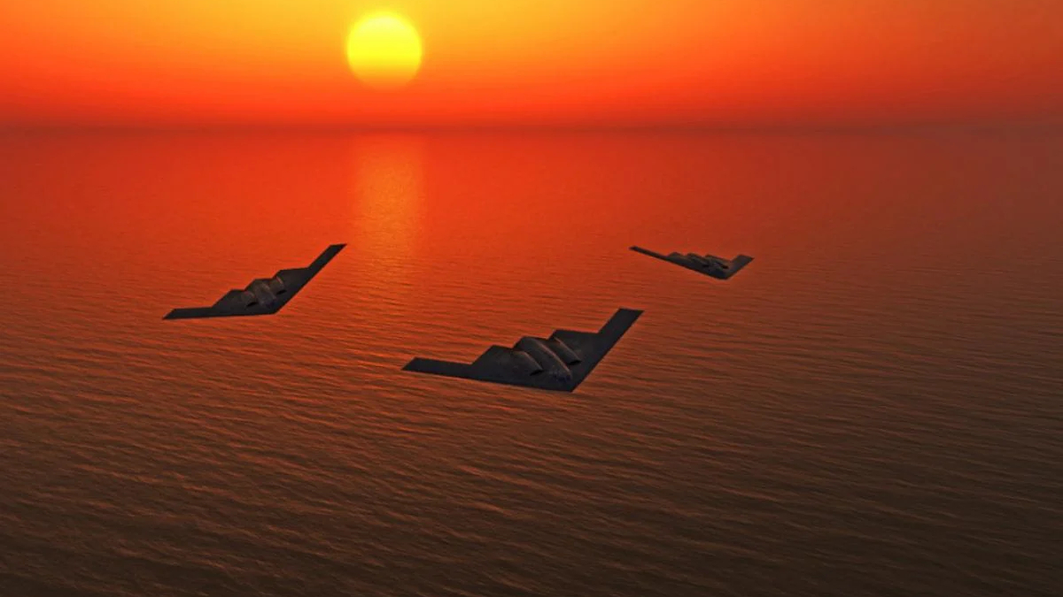 Three stealth bomber aircraft fly in a loose triangle over an orange sunset-lit ocean.