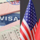 Visa documents and passports beside US and Chinese flags, suggesting international travel or immigration themes.