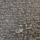 Chalkboard filled with complex mathematical equations, formulas, and diagrams written in white chalk on a dark surface.