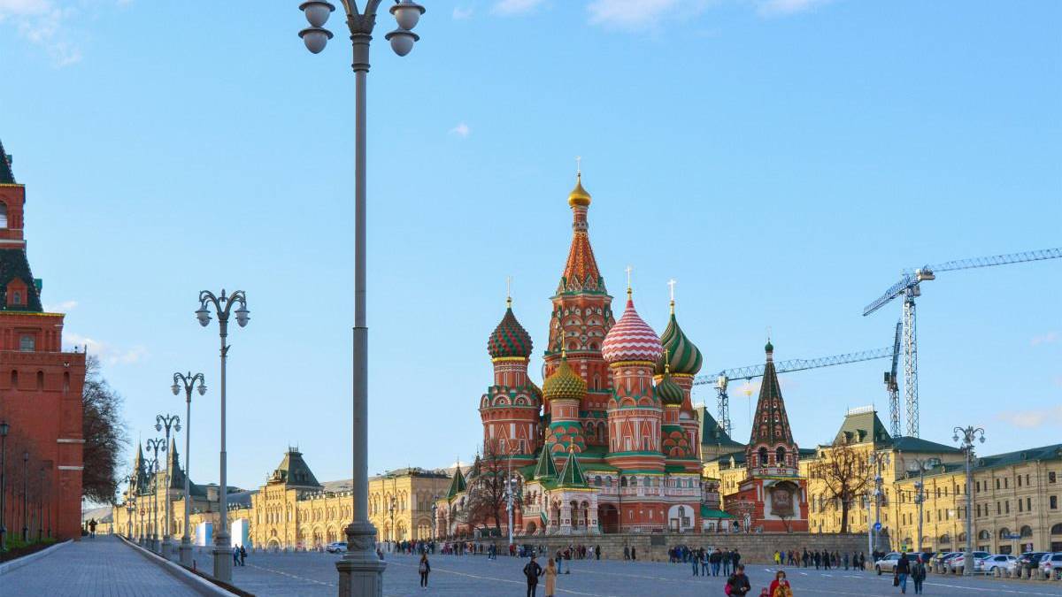 Saint Basil's Cathedral with colorful onion domes in Red Square, Moscow, under a clear blue sky.