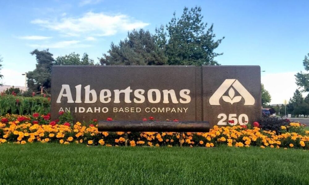 Albertsons sign at entrance with flower bed, Idaho-based company and 250th anniversary logo visible